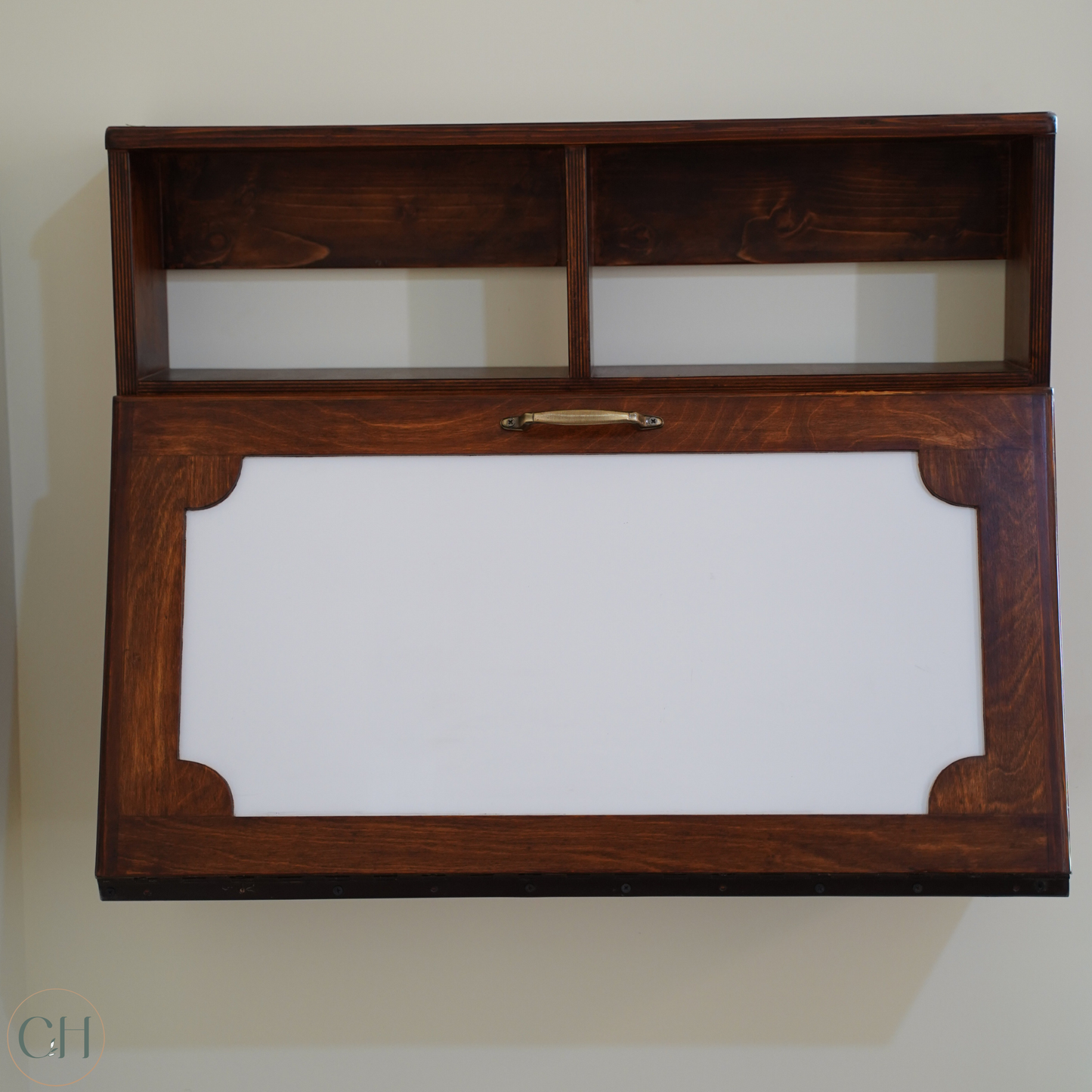 CustHum - Front closed view of a wall-mounted desk in dark wood tone with two small open top shelves and writable white laminate on front panel