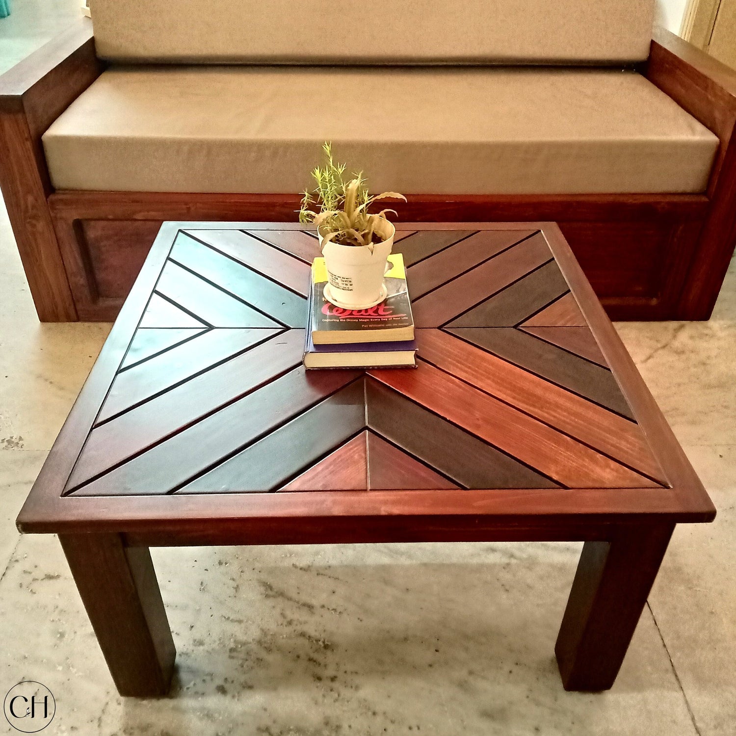 CustHum - Coffee table with herringbone tabletop, showing a small planter placed on stack of books