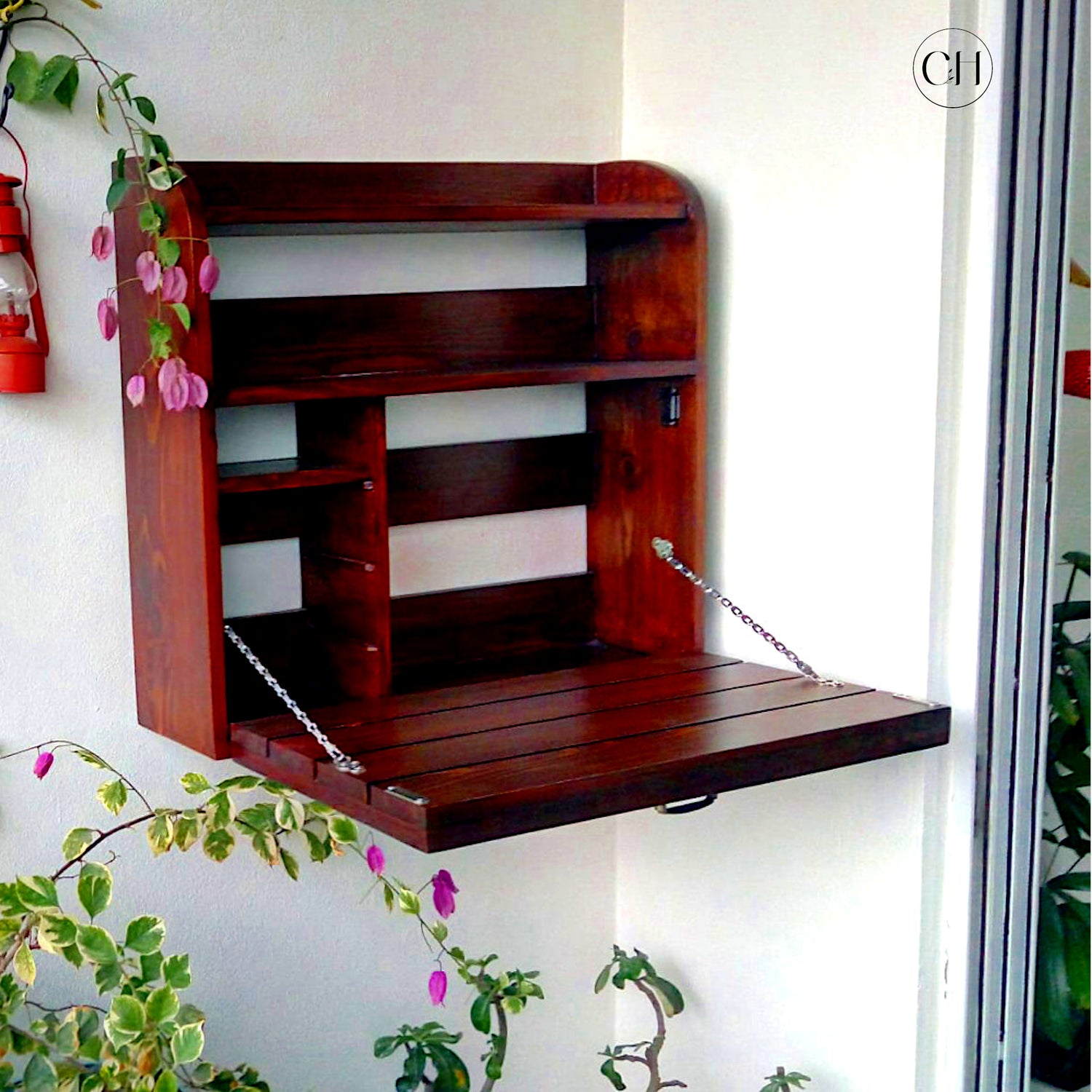 CustHum - Wall-mounted wooden table with shelves inside (open view, bougainvilla in the background)