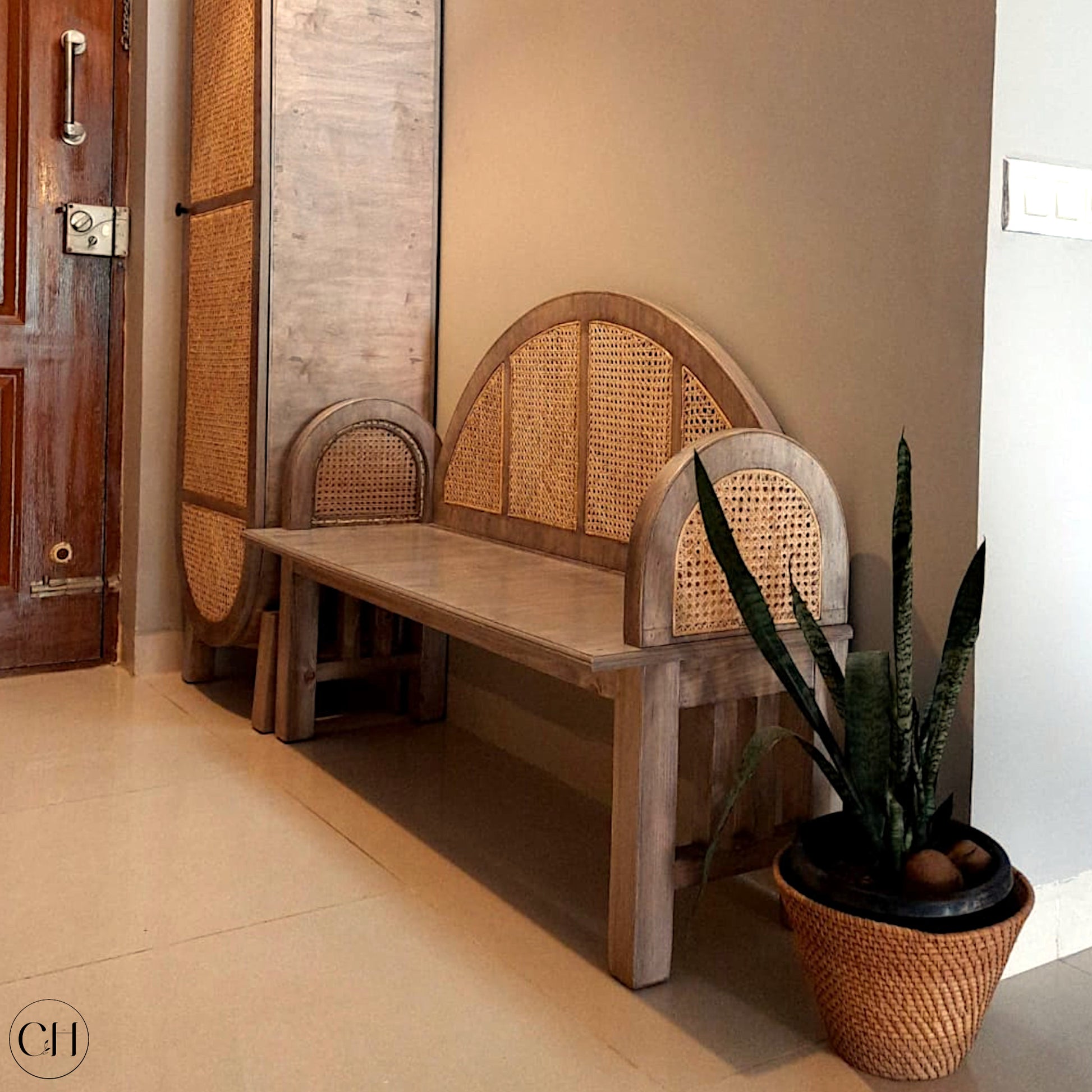 CustHum Elenore - solid wood entryway bench with woven rattan on back and arms (ISO view in foyer with planter))