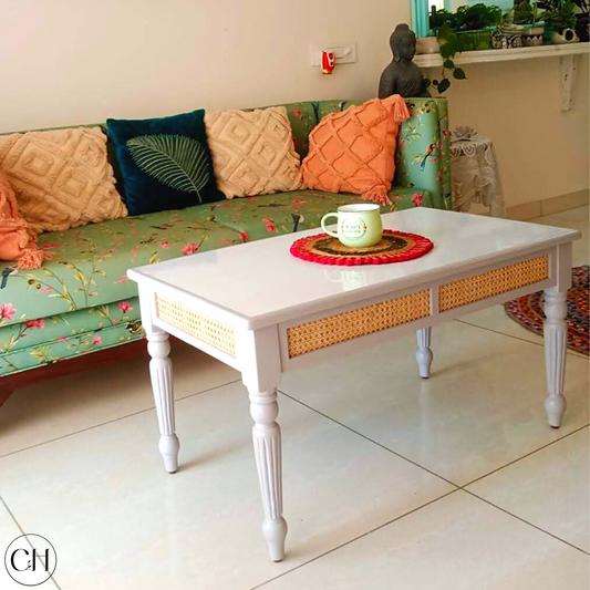 CustHum - Living room view of coffee table with glossy laminated top, rattan accent on apron, turned legs