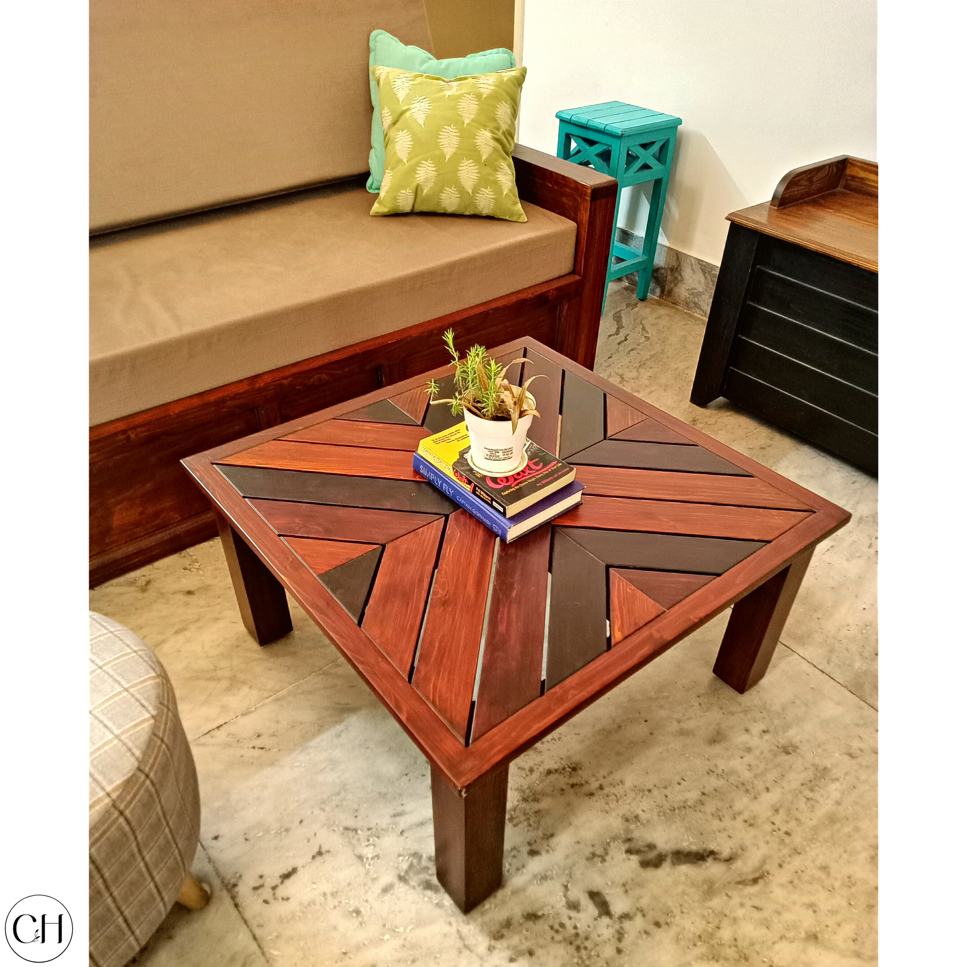 CustHum Corfu - Wooden Centre Table with Herrinbone Top (showing small planter on top of two books, in a living room setting)