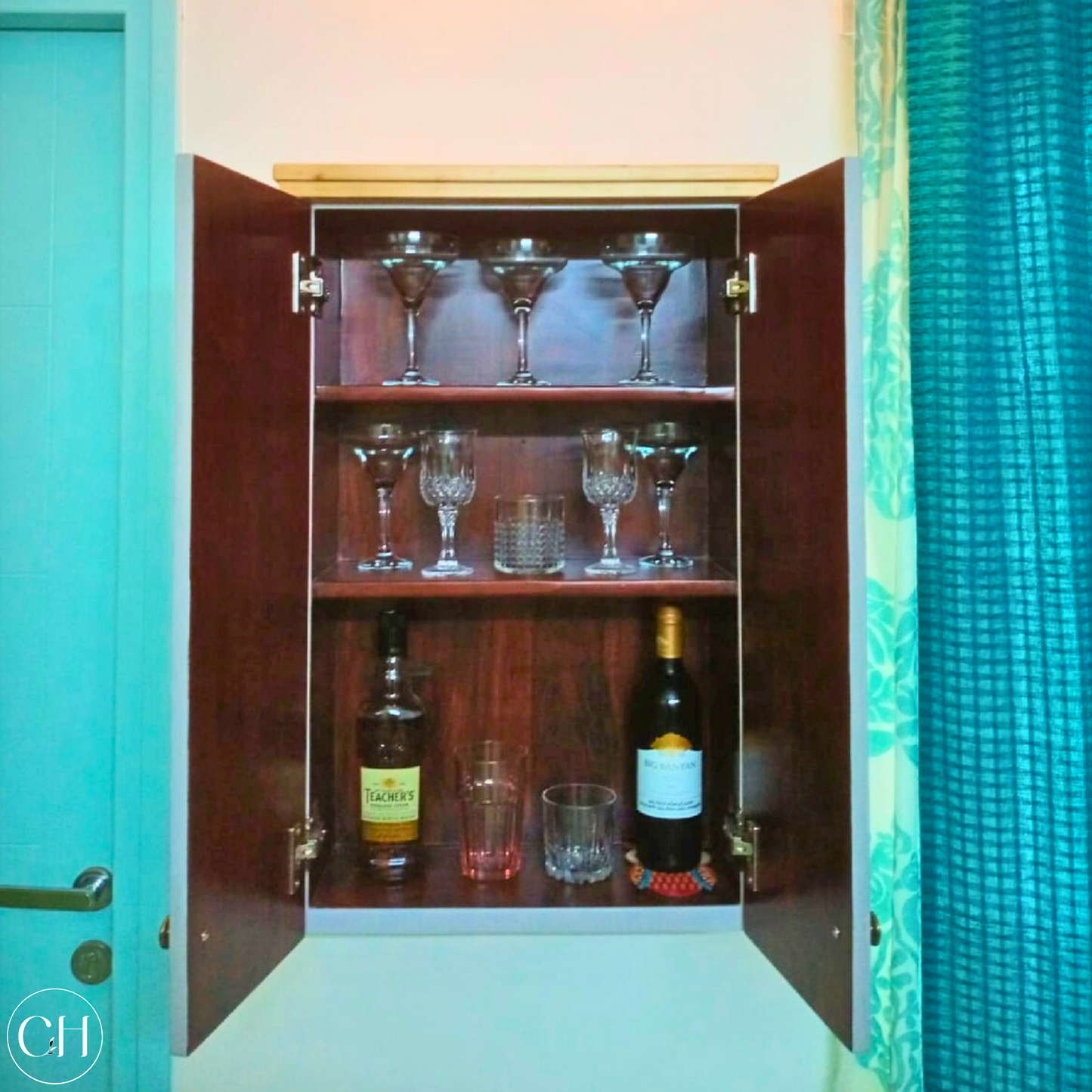 CustHum - Open wall-mounted bar cabinet showing glassware and bottles 